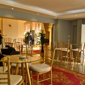 カイロにあるCleopatra Hotelのテーブルと椅子の部屋に立つ男