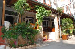 a building with trees and plants in front of it at Rain Hotel in Kizkalesi