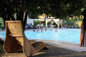 a wicker chair sitting next to a swimming pool at Nicotel Pineto in Castellaneta Marina