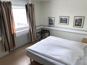 1 dormitorio con cama blanca y ventana en Grand Hotell Bollnäs en Bollnäs