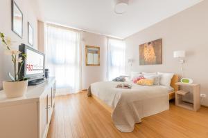 una camera bianca con letto e televisore di P&O Serviced apartments CH ARKADIA 2 a Varsavia