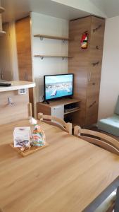 a room with a table and a tv in a room at Mobile Home 701 in Les Mathes
