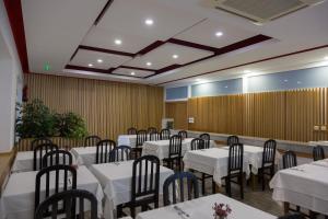 ein Bankettsaal mit weißen Tischen und Stühlen in der Unterkunft Troia Hotel in Amares