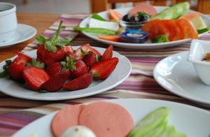 a table topped with plates of strawberries and other foods at Rain Hotel in Kizkalesi