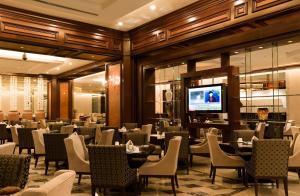 a dining room with tables and chairs and a television at Grand Concordia Hotel in Beijing
