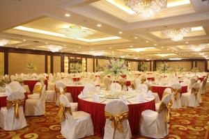 a banquet hall with white tables and chairs and chandeliers at Grand Concordia Hotel in Beijing +49 photos
