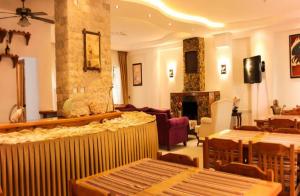 a living room with a fireplace and a living room with tables at Rain Hotel in Kizkalesi