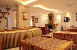 a living room with tables and chairs and a fireplace at Rain Hotel in Kizkalesi