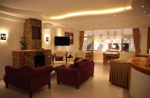 a living room with a fireplace and a dining room at Rain Hotel in Kizkalesi