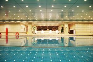 a large swimming pool in a large building with a pool at Grand Concordia Hotel in Beijing