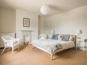 a bedroom with a bed with two chairs and a fireplace at Holly Farm in Doddington