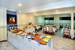 a buffet line with food on it in a restaurant at Hotel Hetropolis in São Bernardo do Campo
