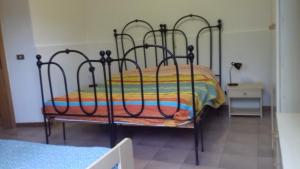 een zwart bed met een kleurrijk dekbed in een kamer bij Camping Agriturist Sant'Anna in Castelplanio