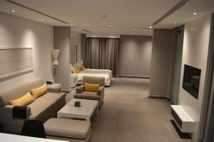 Habitación de hotel con sofá y cama en Rafa Hotel Apart, en Riad