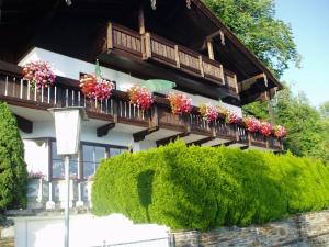 Ein Gebäude mit einem Blumenstrauß auf dem Balkon in der Unterkunft Wallner am See in St. Wolfgang
