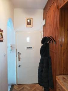 een hond die voor een witte deur staat bij Liszt Apartman in Szombathely