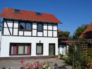 Biały i czarny dom z czerwonym dachem w obiekcie Ferienhaus Jungk w mieście Eisenach
