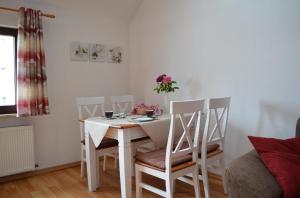 Biały stół i krzesła w salonie w obiekcie Ferienhaus Jungk w mieście Eisenach