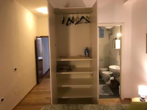 a bathroom with a toilet and a closet with shelves at Carina House in Venice
