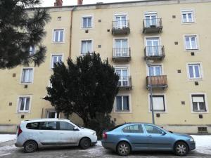 dos coches estacionados frente a un edificio en Liszt Apartman en Szombathely