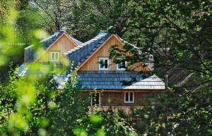 dom z niebieskim dachem w lesie w obiekcie Richňava park w mieście Štiavnické Bane