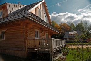 eine Blockhütte mit einer Veranda und einem Haus in der Unterkunft Richňava park in Štiavnické Bane
