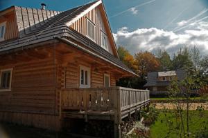 a log cabin with a porch and a house at Richňava park in Štiavnické Bane