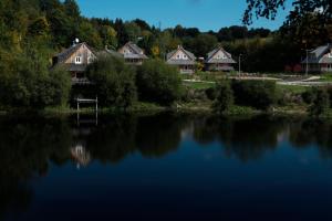 a group of houses next to a lake at Richňava park in Štiavnické Bane