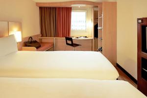 a hotel room with a bed and a desk at ibis Beauvais Aéroport in Beauvais