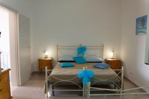 a bedroom with a bed with blue bows on it at Casa Le Pigne in Avola