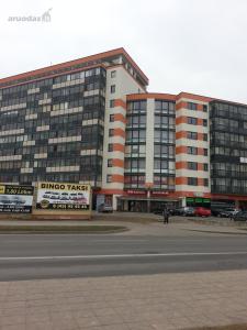 ein großes Gebäude mit einem Parkplatz davor in der Unterkunft Apartments Panevezys in Panevėžys