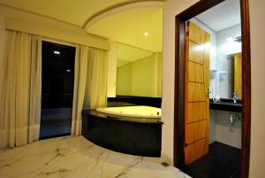 a bathroom with a tub and a large mirror at Los Lagos Resort Hotel in Capiatá
