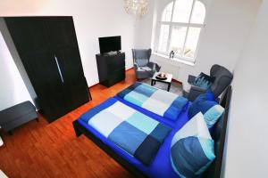 エアフルトにあるSuite an der Furtのベッドルーム(青いベッド1台、椅子付)