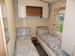 a small room with two beds and a window at Flamingo Land - Woodlands W42 in Kirby Misperton