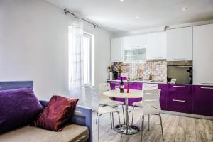 a kitchen with purple cabinets and a table and chairs at Alpha loft 1BR apartment in center in Zadar