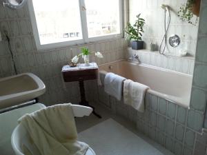 a bathroom with a bath tub and a sink at Ferienwohnung Wilhelmine in Bayreuth +32 photos