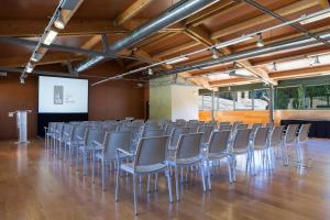 a row of chairs in a room with a screen at Hotel Món Sant Benet in Sant Fruitos de Bages