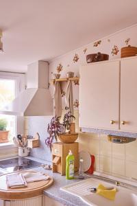 a kitchen with white cabinets and a sink at Ferienwohnung Wilhelmine in Bayreuth