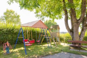 a playground with a swing set next to a tree at BodenSEE Apartment Ravensburg Grünkraut in Grünkraut