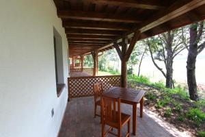 a wooden table and chairs on a porch at Bibic Nature Lodge in Balmazújváros