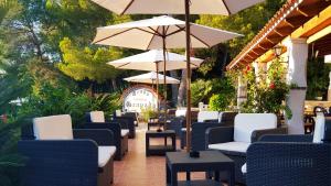 a row of chairs and umbrellas on a patio at Granada Apartments Familiar Deluxe in Portinatx