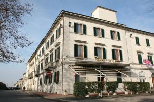 a white building on the corner of a street at Hotel Il Sole in Empoli