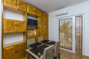 a dining room with a table and chairs and a window at Apartments Jozsef in Splitska