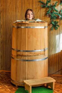 a woman is standing inside of a wooden barrel at Villa Rupcovoto in Smolyan
