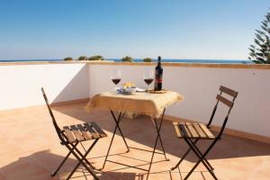 a table with two glasses of wine and two chairs at Casa Le Pigne in Avola