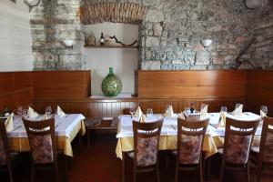 uma sala de jantar com mesas e cadeiras e um vaso em Guesthouse Risnik em Divača