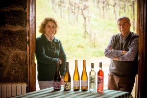 Un uomo e una donna in piedi accanto a un tavolo con bottiglie di vino di Quinta de Lourosa a Lousada