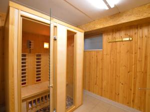 a sauna with wooden walls and a glass door at Cozy Holiday Home in Robertville with Sauna in Robertville