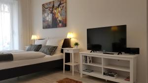 a bedroom with a bed and a flat screen tv at City Apartment, good location in Berlin