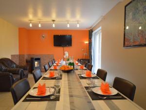 uma longa sala de jantar com uma longa mesa com cadeiras em Cozy Holiday Home in Robertville with Sauna em Robertville